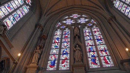 Stained glass windows with religious figures and vibrant colors forming a repetitive, symmetrical pattern, emphasizing spiritual beauty and traditional gothic architecture - Powered by Adobe