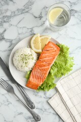 Piece of tasty grilled salmon with rice served on light marble table, flat lay