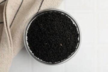 Aromatic black caraway in glass bowl on white table, top view
