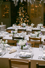Elegant dining setup with floral arrangements and festive decorations in a cozy venue during the holiday season