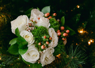 White rose bouquet with greenery and decorative berries arranged elegantly for a festive celebration