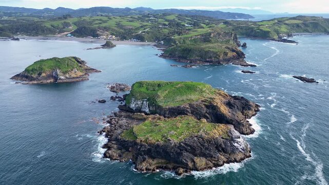 Chiloe Island, Chile: Aerial drone footage above islet by Pu&ntilde;ihuil coast of Ancud in Chiloe island, Lake District of Chile on sunny day. Taken with forward motion toward the beach and coastline
