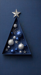 Christmas tree decoration with blue and silver baubles and stars in triangular frame on textured blue background
