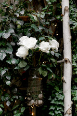 Elegant white roses in a beautifully arranged vase surrounded by lush greenery