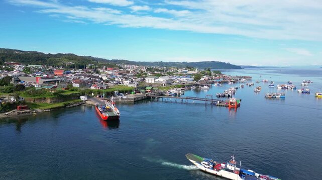 Dalcahue, Chile - November 08 2025: Aerial drone footage above Dalcahue, port city in Chiloe Island, Los lagos region of Chile. With backward motion showing car ferry sailing in pacific ocean