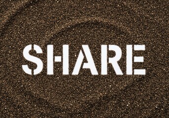 The word share stenciled in white on a dark brown textured surface like sand or soil from a top view
