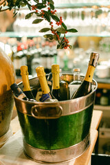 Festive gathering at a bar featuring chilled champagne bottles in an ice bucket with decorative greenery