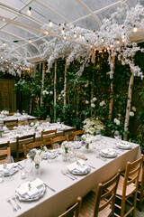 Elegant outdoor dining setup with floral decor and soft lighting in a garden setting