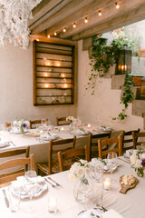 Elegant dining setup in a decorated venue with soft lighting and floral arrangements for a special occasion