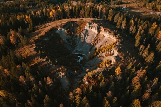 Aerial view of a forested crater with autumn foliage and a winding stream - Powered by Adobe