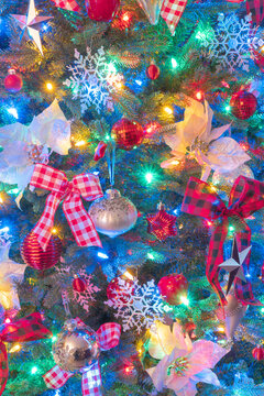 Christmas Tree close up with white Poinsettias, red and white bows and snowflakes