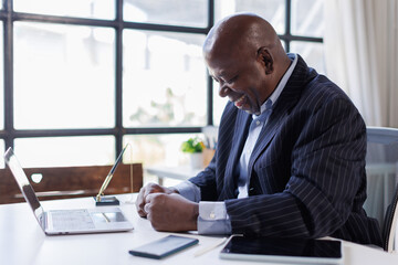 Sad and frustrated man feeling tired and worried about a problem sitting at office with laptop,stressed 60 year old male having problems reading bad news online, email notification about debt