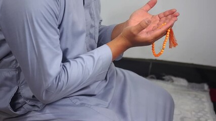 Praying with raised hands. A Muslim man prays with both hands raised. Procedures for worship in Islam. - Powered by Adobe