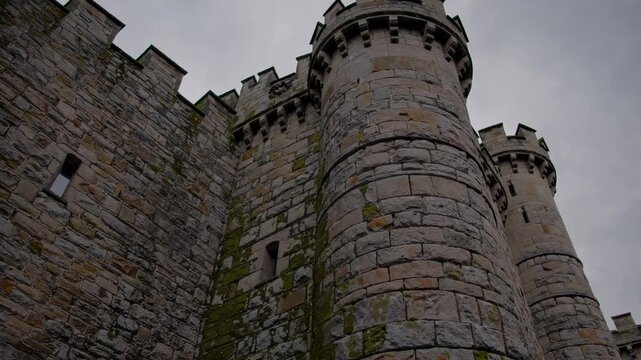 Medieval castle stone walls and imposing towers rising against cloudy sky. Showcasing architectural strength. Historical significance. And enduring architectural heritage from european medieval times