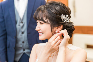 Smiling bride and groom getting ready for wedding ceremony and reception (bridal jewelry and accessories)
