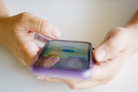 Close-up of hands holding and using a smartphone with touchscreen interface, illustrating modern technology, communication, and mobile lifestyle in everyday digital life and online interaction.