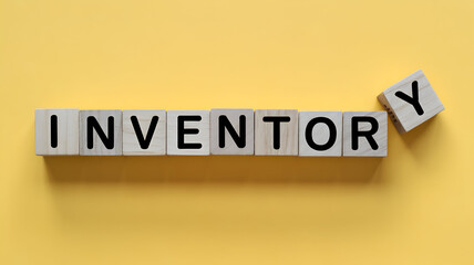 Wooden blocks spelling inventory on a yellow background representing stock management supply chain and business operations for retail and ecommerce success