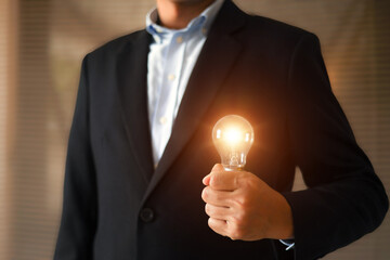 Businessman's hand is choosing light bulb for business creativity plan to goal or creative idea innovation or analyzing marketing data management and target growth or human resources.