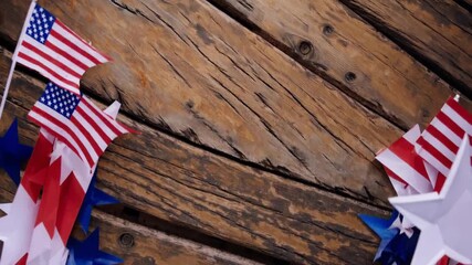 American flags and patriotic star shaped decorations hanging against a textured weathered wooden background, symbolizing national pride, independence, and celebration - Powered by Adobe