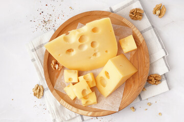 Plate with pieces of Swiss cheese and walnut on white background