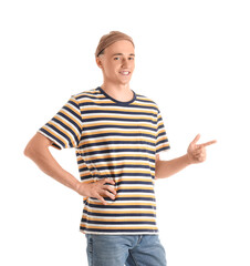 Handsome young man in striped t-shirt pointing at something on white background