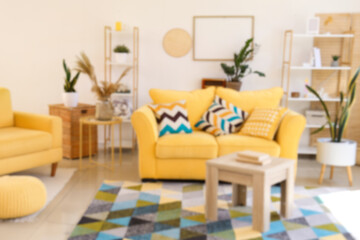 Interior of light living room with yellow sofa and tables