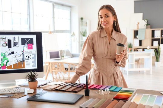 Female interior designer with cup of coffee working in office