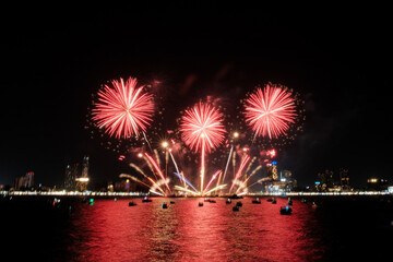 Spectacular colorful fireworks at Pattaya International Fireworks Festival 2025 viewed from a raft in the middle of Pattaya ocean. Vibrant reflections light up the dark ocean in Pattaya Bay, Thailand.