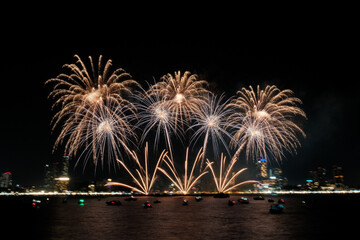 Spectacular colorful fireworks at Pattaya International Fireworks Festival 2025 viewed from a raft in the middle of Pattaya ocean. Vibrant reflections light up the dark ocean in Pattaya Bay, Thailand.