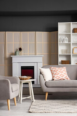 Interior of living room with electric fireplace and sofa