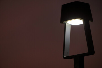 An LED bollard light, outdoor lighting fixture. Light with dusk background.