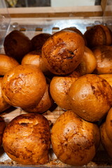 Freshly baked golden bread rolls stacked in a display at a local bakery in the early morning