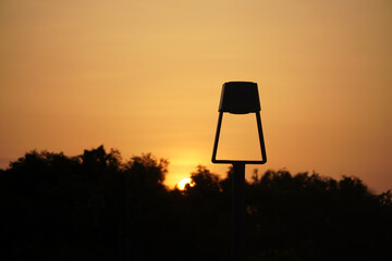 An LED bollard light, outdoor lighting fixture.. Sunset in the countryside.