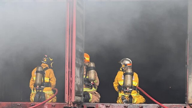 Firefighters battle intense flames during a rescue operation in an outdoor setting. Firefighters combat a large blaze during a training exercise in the evening glow