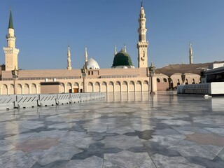 A beautiful mosque reflecting on the stone courtyard outdoors