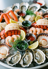An opulent, vertical close-up of a massive chilled seafood tower or platter, arranged on crushed ice.