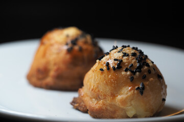 Hot, golden pastries sit on a white plate, ready to enjoy