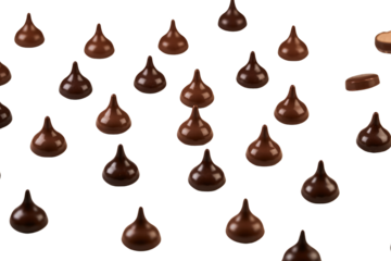 Chocolate drop candies wrapped in foil (or unwrapped chocolate) are scattered across a white surface. 