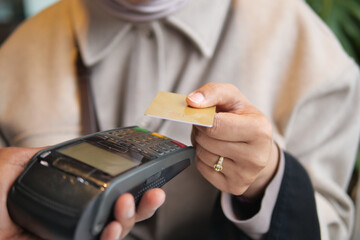 Paying with a card at a store in an urban setting