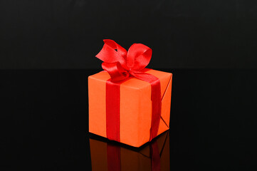 Isolated orange gift box on a black background.