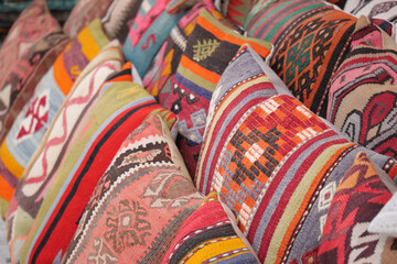 Craftspeople display colorful handmade cushions at a market