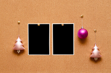 Empty photos and Christmas tree toys are pinned on a cork board. Copy space