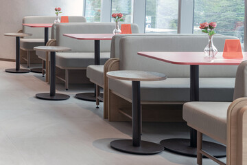 a row of tables and booth-style seating in a clean and modern interior of a restaurant.