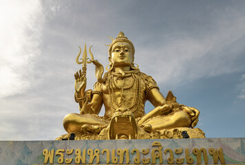 Fototapeta premium a large golden statue of Lord Shiva is a major deity in Hinduism.
