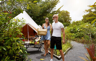 A man and a woman are leisurely walking down a scenic path at the glamping
