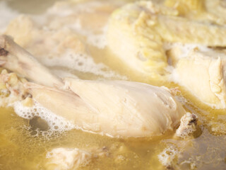 Raw Chicken Pieces Cooking in Golden Broth for Homemade Soup Preparation