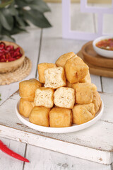 Delicious Deep Fried Tofu Puffs with Tea and Berry Tart on Rustic Wooden Table