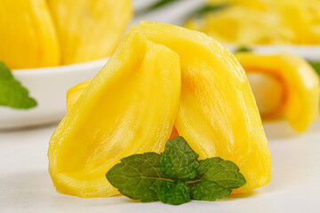 Fresh Sliced Yellow Tropical Fruit with Mint Leaves on White Background © PhanThi