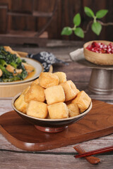 Deep Fried Golden Tofu Puffs in Bowl with Asian Cooking Ingredients on Wooden Table