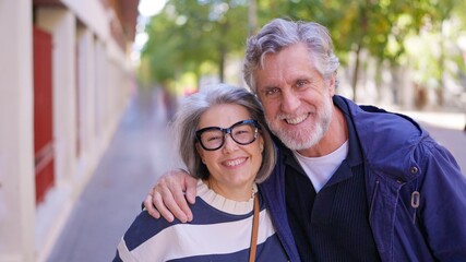 Happy senior couple hugging and smiling outdoors